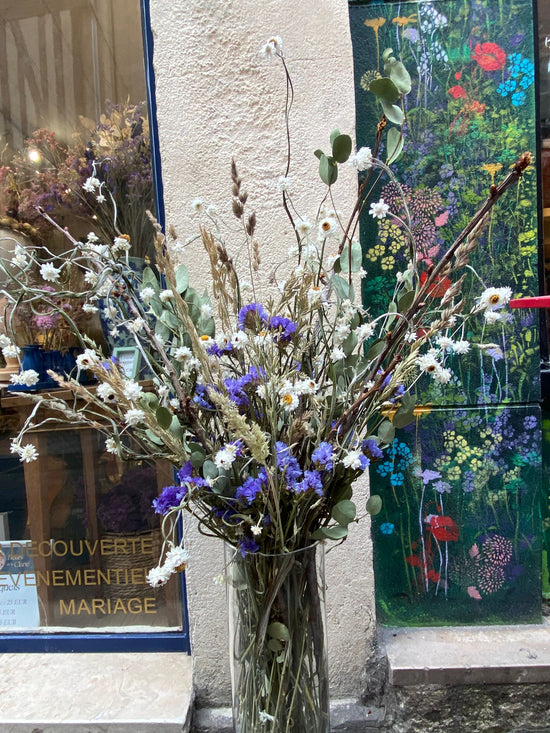 Bouquet de fleurs séchées devant la devanture fleuriste